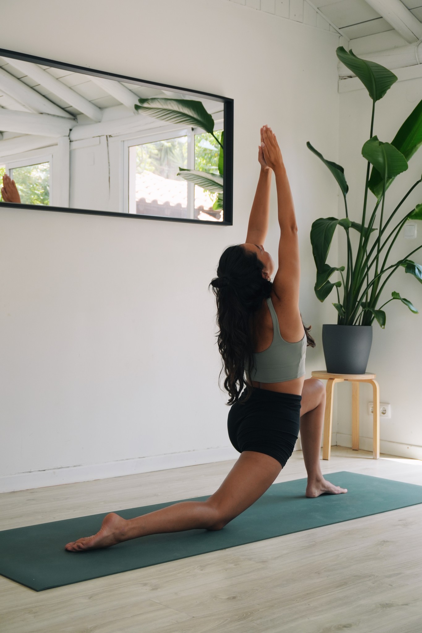 Alanis in einer Vinyasa-Haltung mit gestreckten Armen auf der Matte.